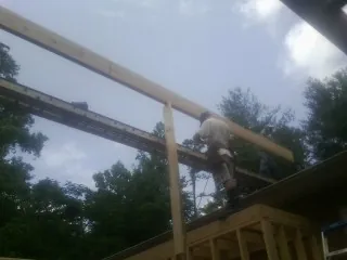 Carpenter setting a ridge beam over a new addition frame — Ice Dam Removal by Roofing Brothers in Ringgold