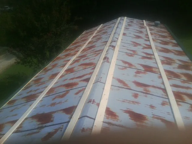 Rusted metal roof panels with new wood purlins before replacement — Storm Damage Roof Repair in Ringgold by Roofing Brothers